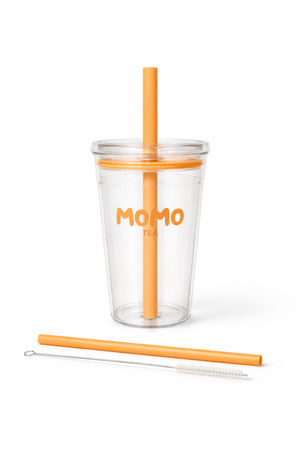 Clear tumbler with orange straw and cleaning brush on a white background